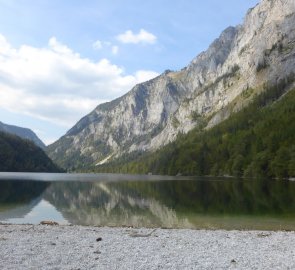 Kamenitá pláž jezera Leopoldsteiner See u bistra Seestüberl